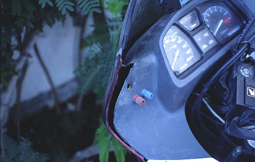Verbogener Verkleidungshalter und beschädigte Verkleidung.