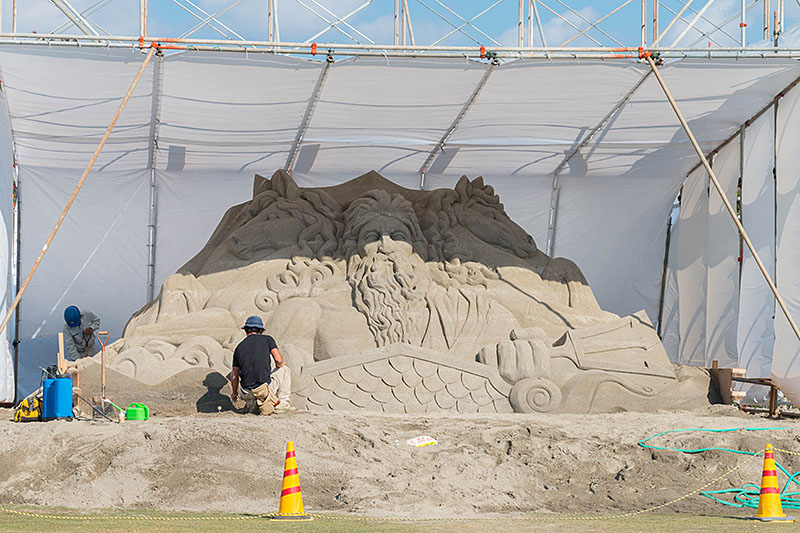 Ein Künstler mit seiner Sand-Skulptur