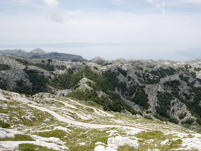 Im Vordergrund die Kehren und hinten das 1,7 Kilometer tiefer liegende Meer
