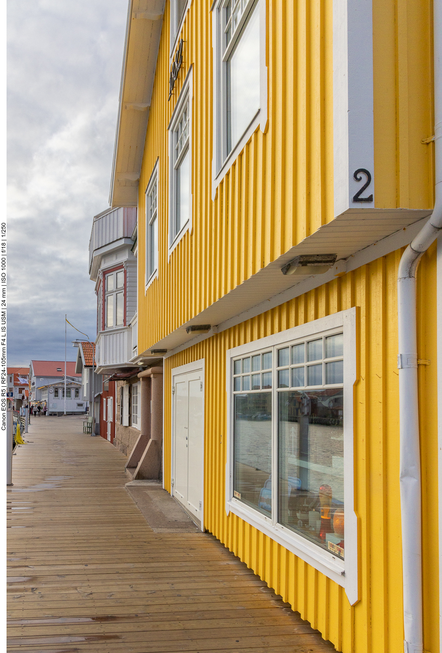 Farbenfrohe Häuser reihen sich entlang des kleinen Hafens, mal gelb ...