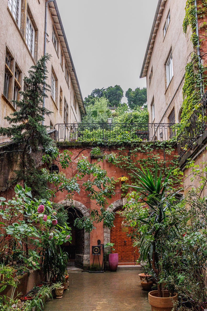 Diese historische Traboule befindet sich im Vieux Lyon (Altstadt von Lyon). Die Gegend ist bekannt für ihre versteckten Gänge aus der Renaissance-Zeit und gehört zum UNESCO-Weltkulturerbe. Die abgebildete Passage ist typisch für die architektonischen Details der 5. Arrondissements von Lyon.