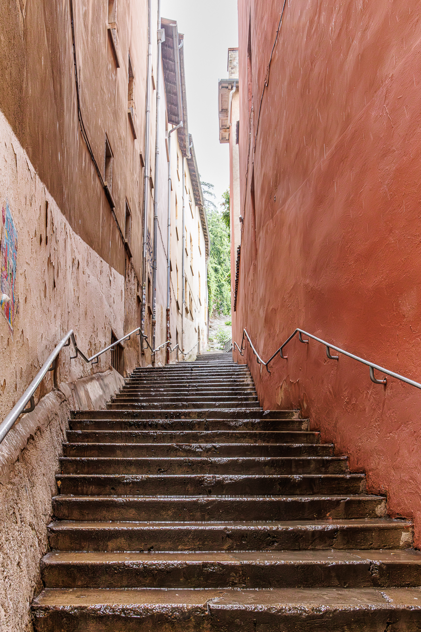 Über diese (und weitere) steile Steintreppen in der Altstadt steigen wir auf den Hügel Fourvière hinauf. Die Treppe wird von historischen, eng beieinander stehenden Gebäuden mit charakteristischen Fassaden gesäumt.