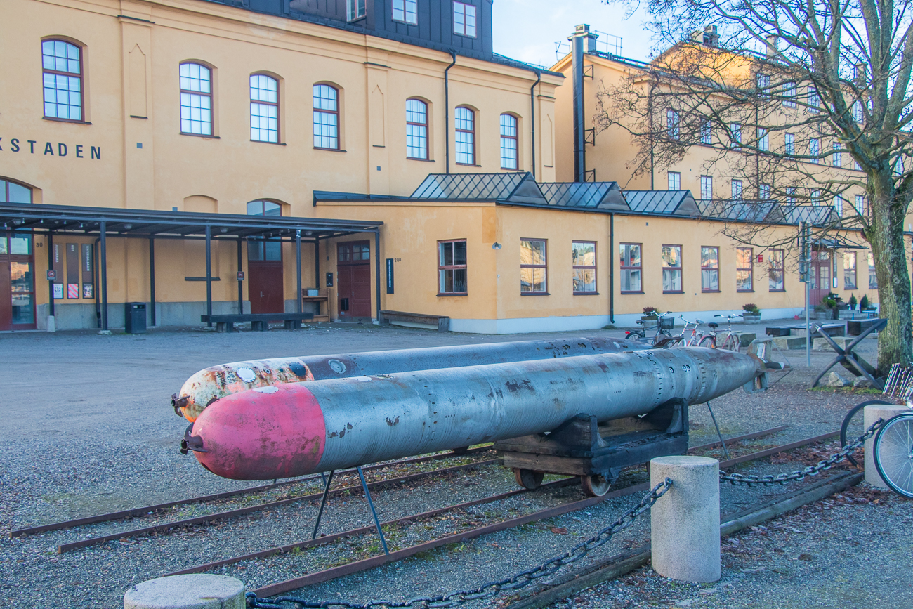 Ein paar Torpedos liegen als Schauobjekte vor der Werkstatt 