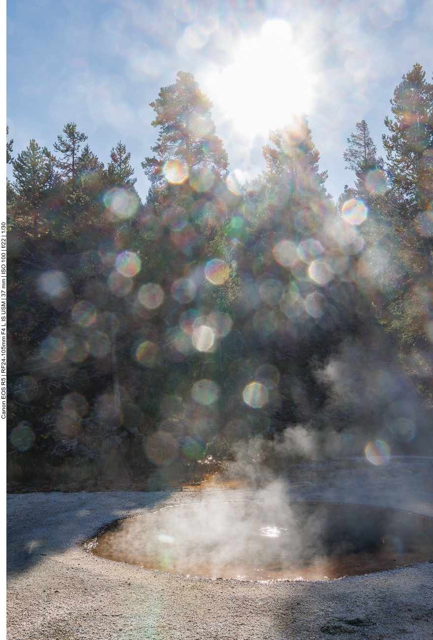 Tröpfchen spiegeln sich im Sonnenlicht über einem brodelnden Becken